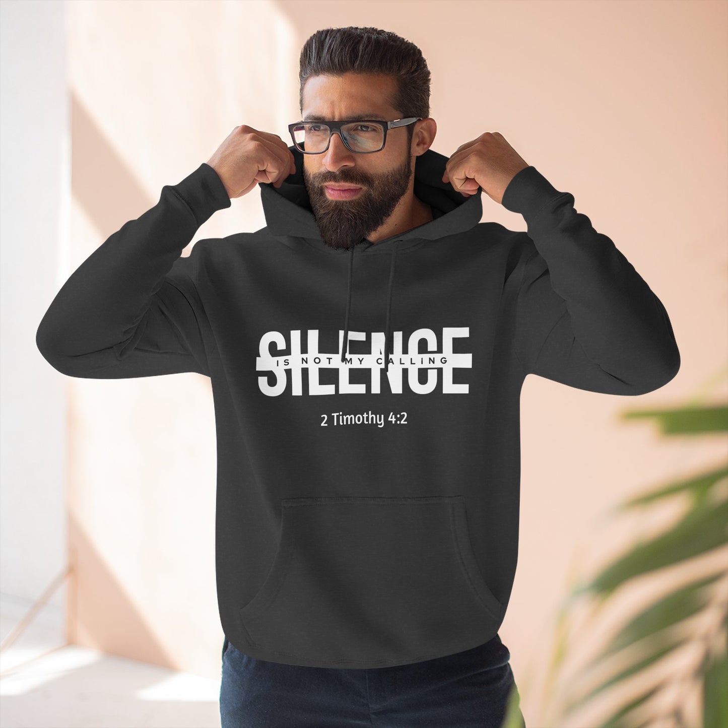 Man wearing a black hoodie with 'SILENCE is not my calling 2 Timothy 4:2' text.